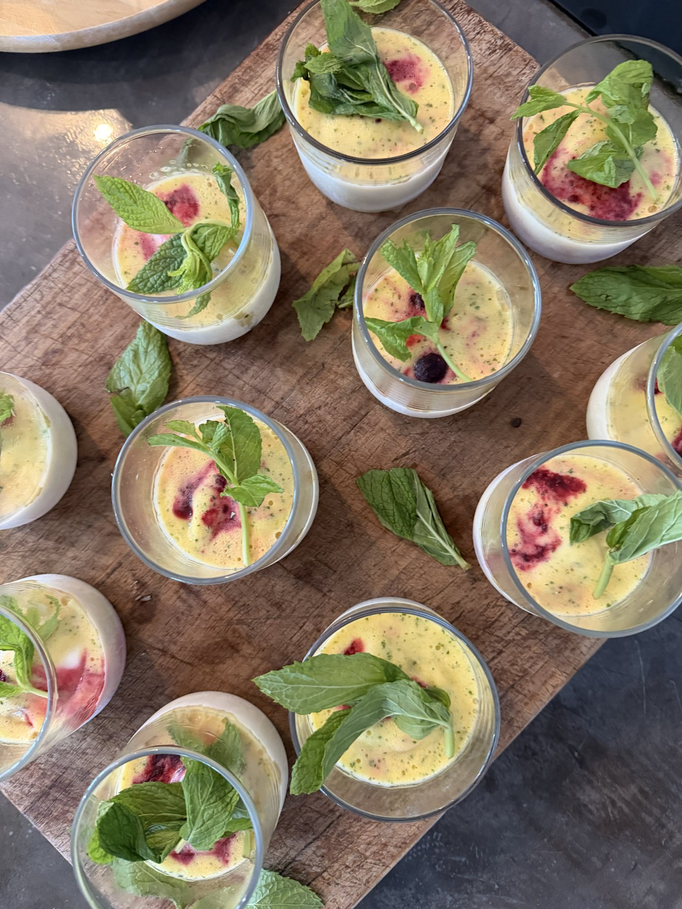 Individual desserts topped with berries and fresh mint