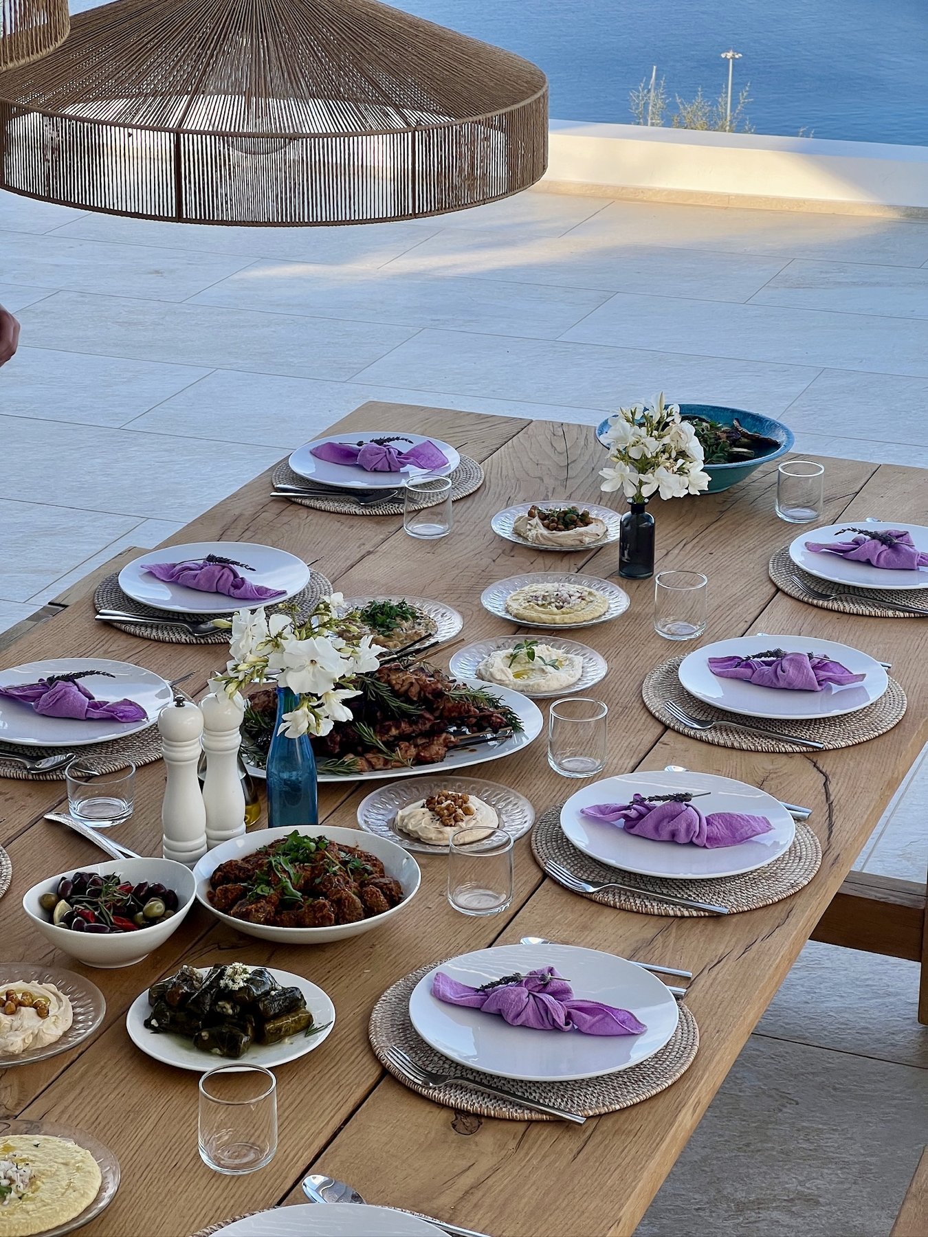 Long dining table prepared for a seafront dinner