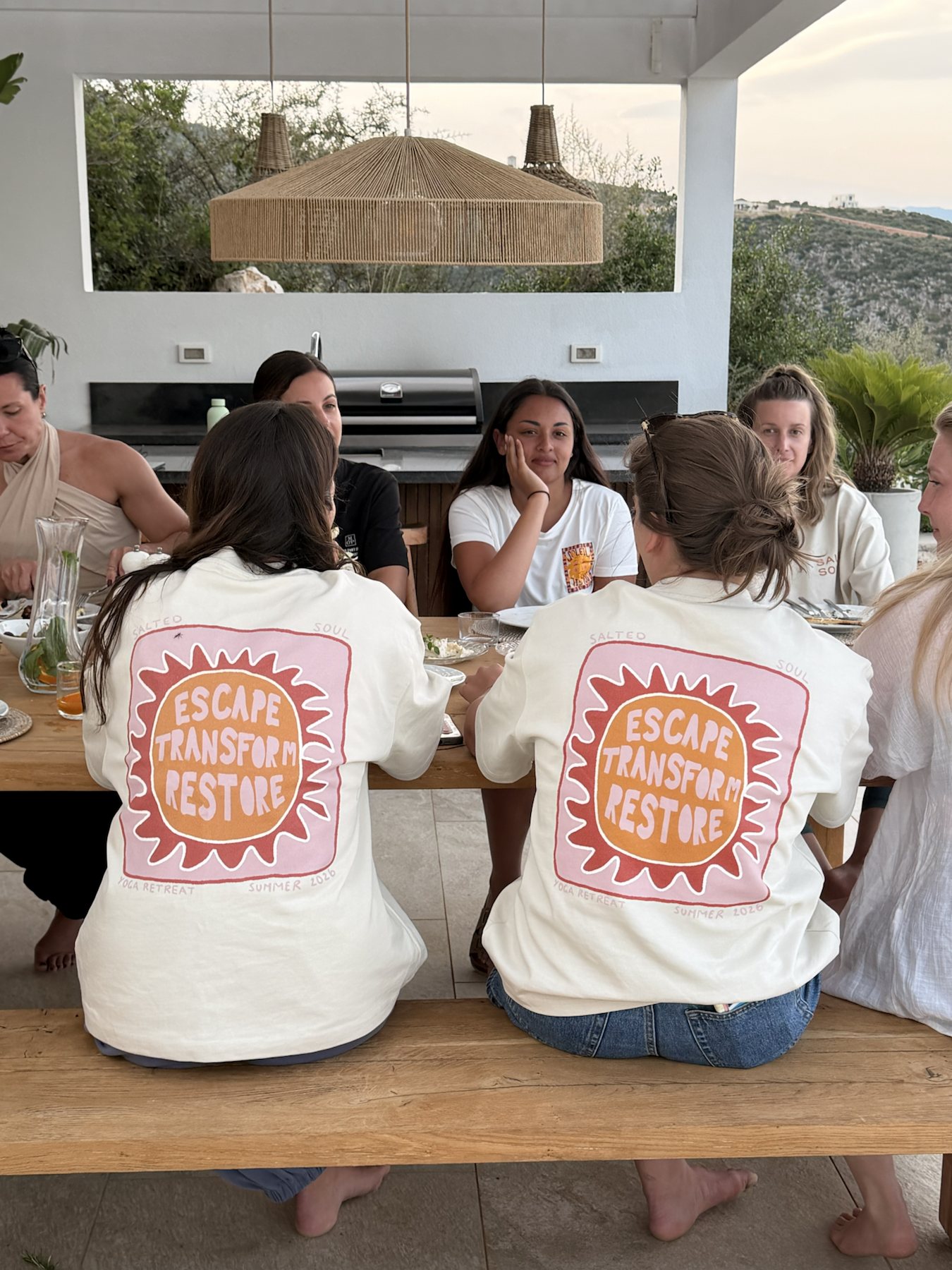 Guests gathered around the villa table in Salted Soul tops