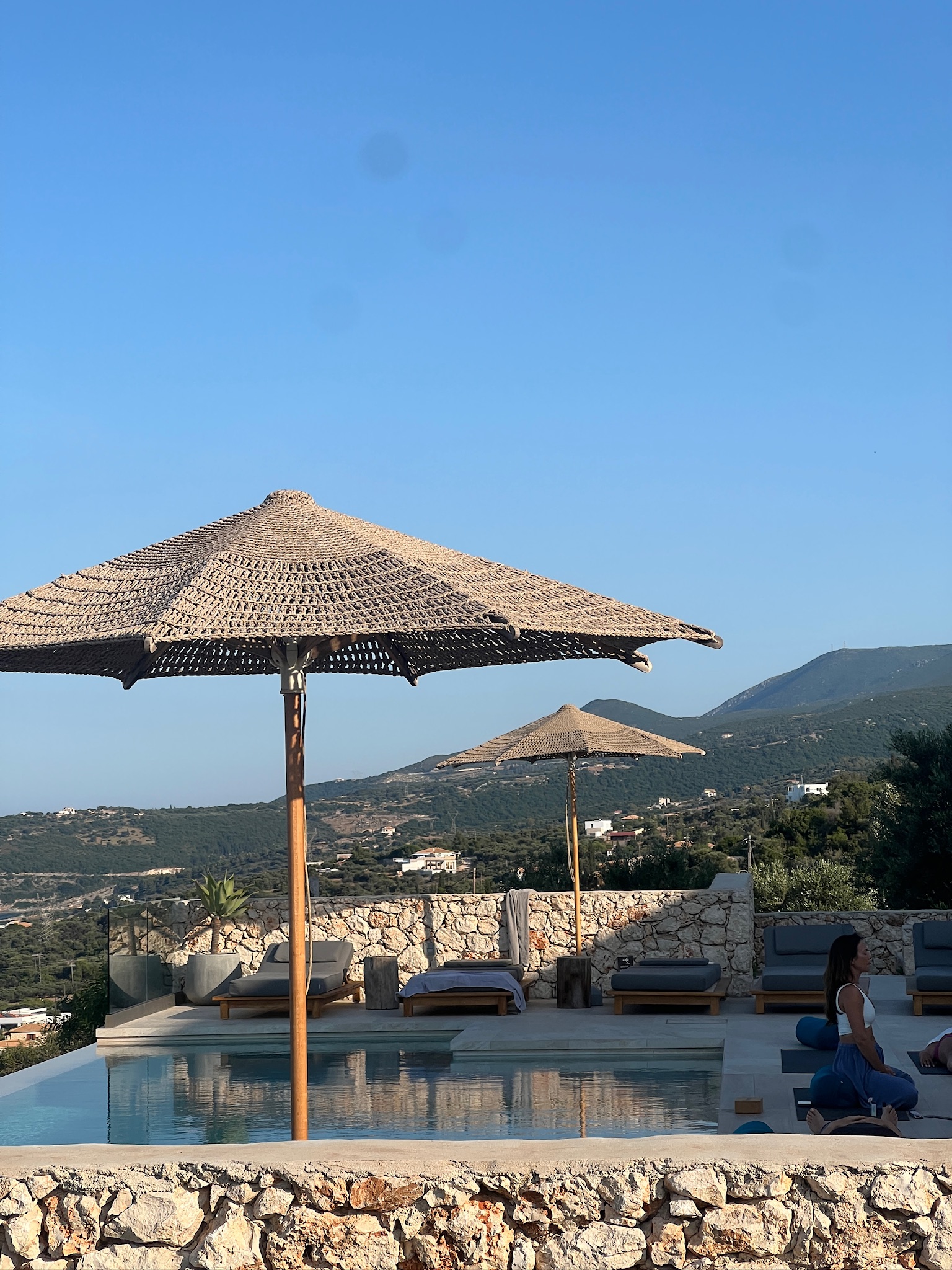 Pool terrace with umbrellas and hillside views